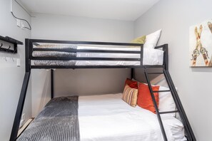 A bunk bed with a mattress, pillows, and a headboard. - Walk to Festivals and Lift 7 | Remodeled 3BR Condo | Hot Tub + Garage Parking (Telluride)