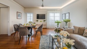 A modern living room with a dining area, a sofa, a coffee table, and a TV. - Elegant Modern Apartment with Terrace in Historic Lucca (Lucca)