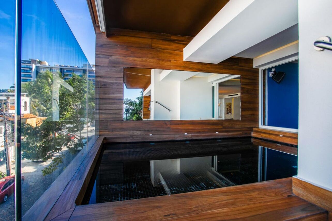 A modern interior with a wooden accent wall, a glass window, and a view of the city.