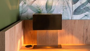 Ein modernes Badezimmer mit einem Holzkosmetikschrank, einem wandmontierten Spiegel und einem großen abstrakten Blattmuster.