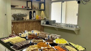 Een buffet met diverse gerechten, een koffiehoek en een raam met uitzicht.