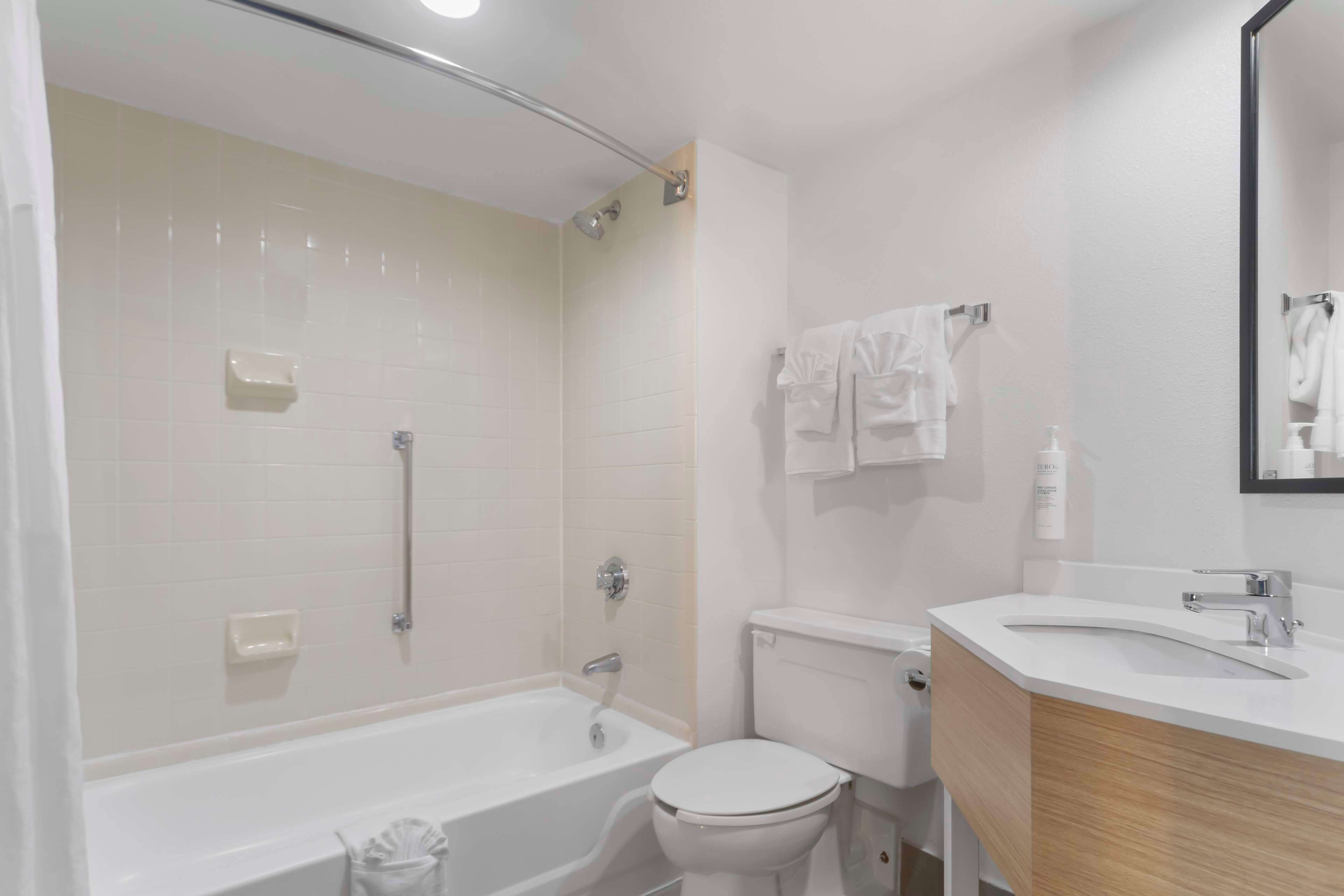A modern bathroom with a bathtub, toilet, and sink.