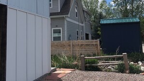 A residential area with a house, a shed, and a gravel driveway.