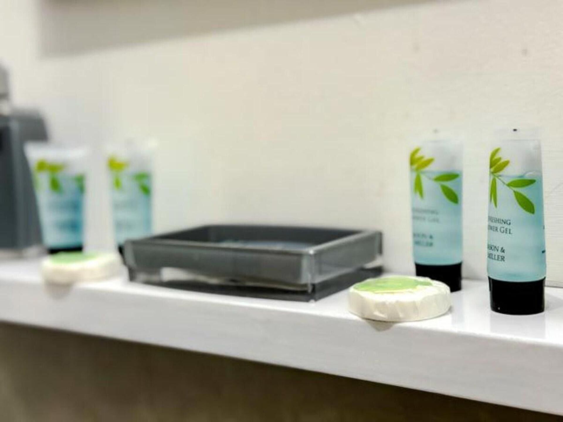 Une étagère contenant des produits de soins pour la peau, notamment un nettoyant pour le visage et un gel hydratant.