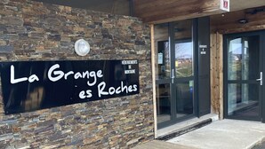 Ein Gebäudeeingang mit einer Steinmauer und einem Schild mit der Aufschrift 'La Grande es Roches'.