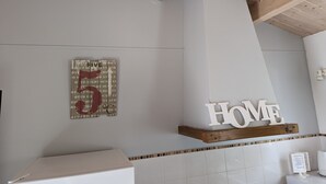 Casa de banho moderna com teto de madeira, uma pia branca e o letreiro 'HOME' acima da pia.