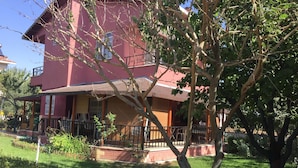Une maison à deux étages avec un balcon et un petit jardin.