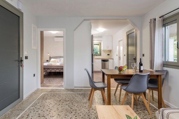 Une chambre d’hôtel compacte comprenant un coin repas, une kitchenette et un lit.