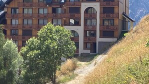 A multi-story hotel with wooden balconies and a central entrance.