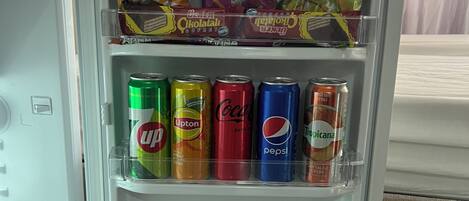 Een koelkast gevuld met verschillende drankjes en lekkernijen.