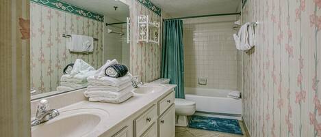 A bathroom with a sink, mirror, and toilet.