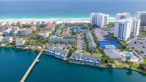 A coastal hotel with multiple buildings, a marina, and a beach view.