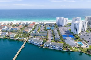 A coastal hotel with multiple buildings, a marina, and a beach view.