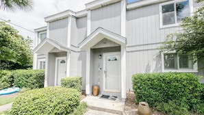 A two-story building with a symmetrical facade, a central entrance with a door and a small porch, and a number '34' above the door. - Southbay by the Gulf 34 (Destin)