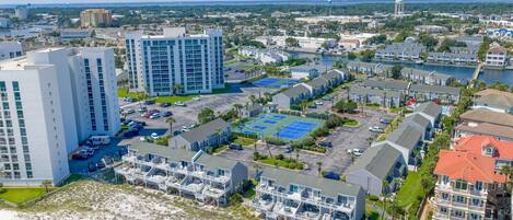 A coastal residential area with multi-story buildings, a marina, and a beach.