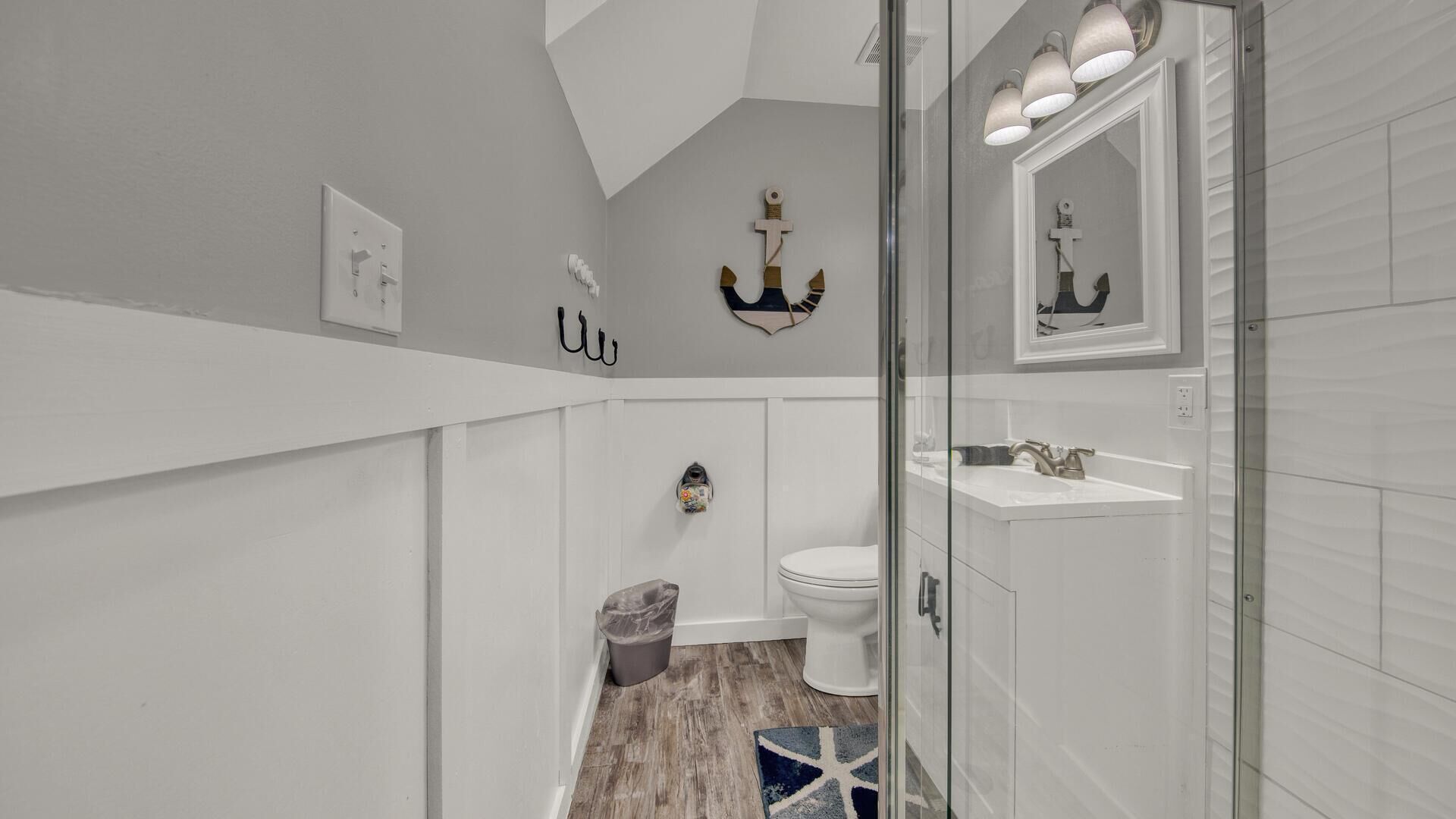 A bathroom with a white vanity, a toilet, and a shower area.