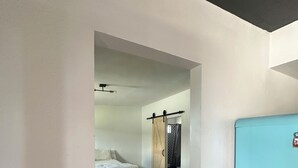 A bedroom with a bed, a dresser, and a blue refrigerator. - Furnished apartment in a great country setting. (Blythe)