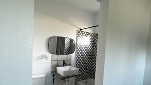 A small, compact bathroom with a toilet, sink, and bathtub. - Furnished apartment in a great country setting. (Blythe)