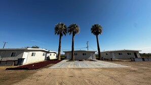 A row of single-story mobile homes with a clear blue sky. - Furnished apartment in a great country setting. (Blythe)