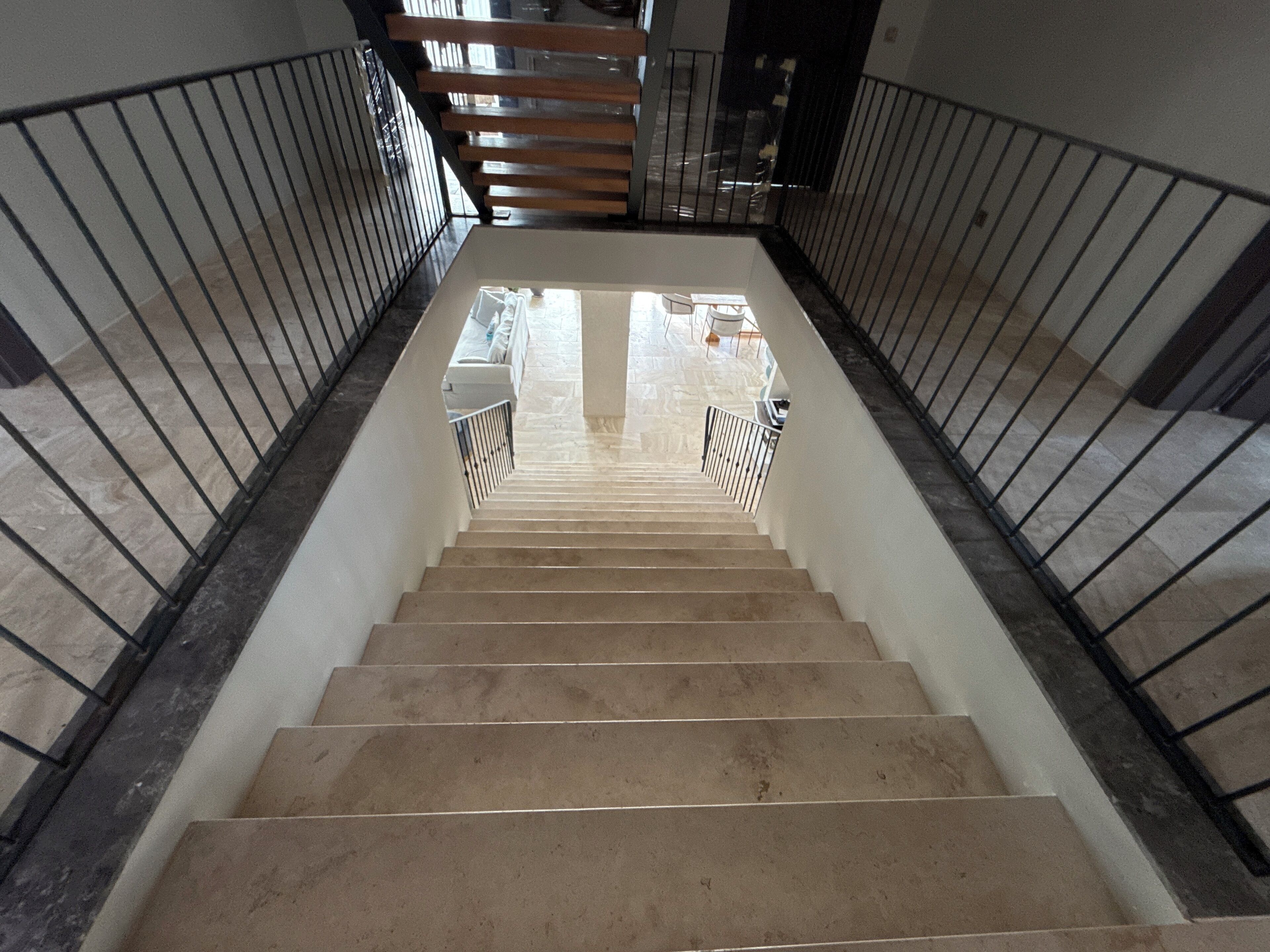 A staircase with a handrail, leading to an upper floor.