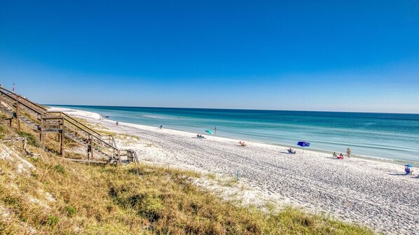 A beach with a wooden staircase leading down to the shore, a sandy beach, and the ocean. - Hidden Lake Condos 113 (Santa Rosa Beach)
