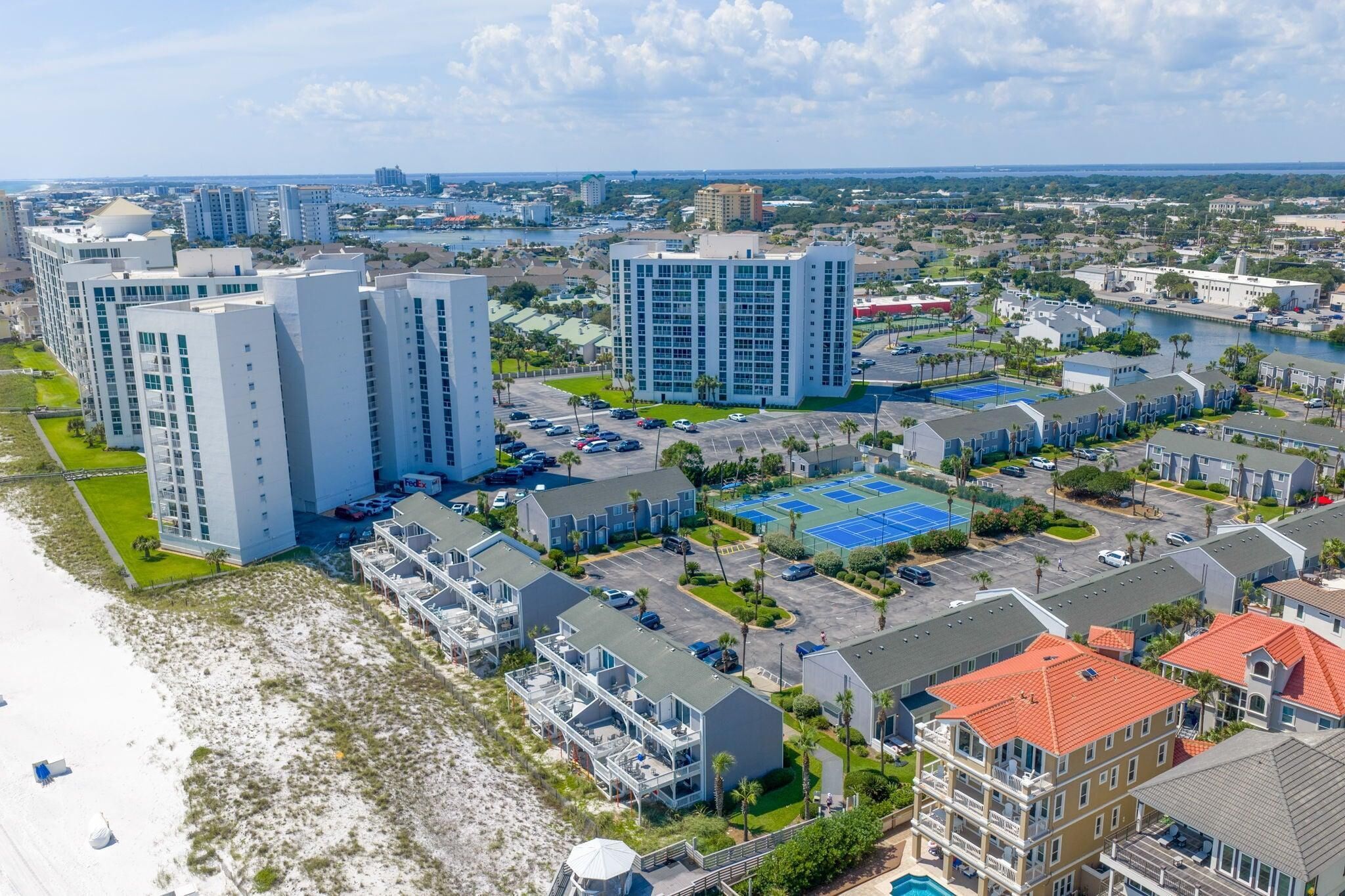 A coastal residential area with high-rise buildings, a marina, and a beach.
