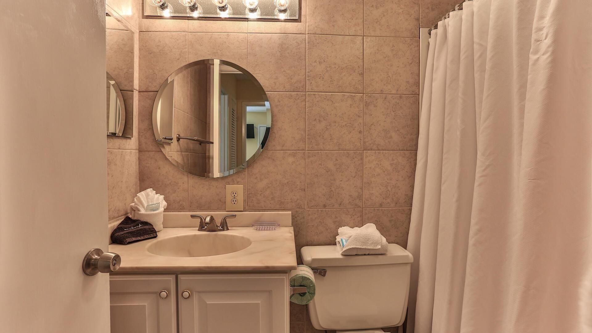 A bathroom with a sink, mirror, and toilet.