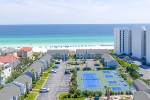 A coastal hotel with a beachfront view, multiple tennis courts, and a parking lot. - Southbay by the Gulf 99 (Destin)