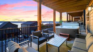 Un espace extérieur aménagé, abrité et doté d’un jacuzzi, d’une terrasse en bois et d’une vue sur l’eau.