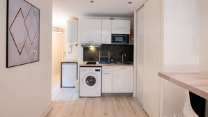 A compact kitchen with a washing machine, microwave, and sink. - Central Part-Dieu - Apartment 2 - A/C available (Lyon)