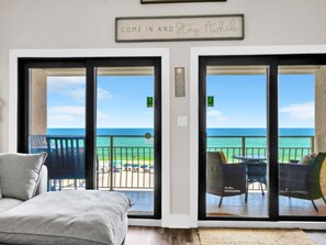 A room with a bed and a view of the ocean through large sliding glass doors. - Crystal Villas 12B (Destin)
