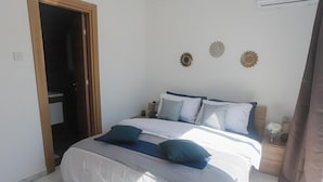 A bedroom with a bed, pillows, a nightstand, and a wall decoration. - Stunning 2 Bedroom, 2 Bathroom apt St Julians (St. Julian's)