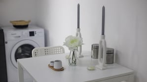 A white table with a vase of white flowers, two candles, and a small bowl. - Stunning 2 Bedroom, 2 Bathroom apt St Julians (St. Julian's)