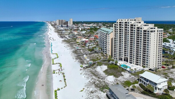 A coastal hotel with multiple high-rise buildings, a beach with umbrellas, and a clear view of the ocean. - Hidden Dunes Gulfside 502 (Miramar Beach)