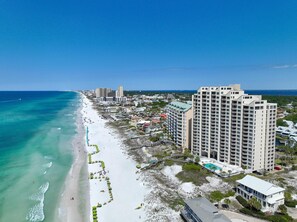A coastal hotel with multiple high-rise buildings, a beach with umbrellas, and a clear view of the ocean. - Hidden Dunes Gulfside 502 (Miramar Beach)