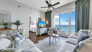 A spacious living room with a balcony, a television, and a dining area. - Leeward Key 1103 (Miramar Beach)