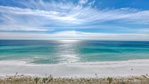 Ein Strand mit blauem Himmel und ruhiger See.