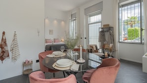 A dining area with a round table, pink chairs, and a candle centerpiece. - Piccola Como Lotus With 1 Bathrooms (Carate Urio)