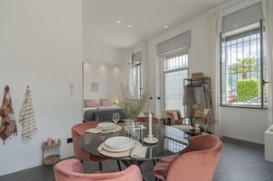 A dining area with a round table, pink chairs, and a candle centerpiece.