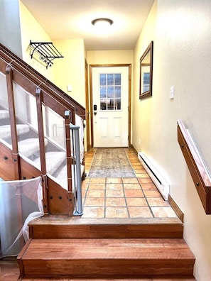 A wooden staircase leading to a door with a window, a wall-mounted light fixture, and a small rug on the floor. - 3 Bedroom Townhome 1 Block from Main St Frisco (Frisco)