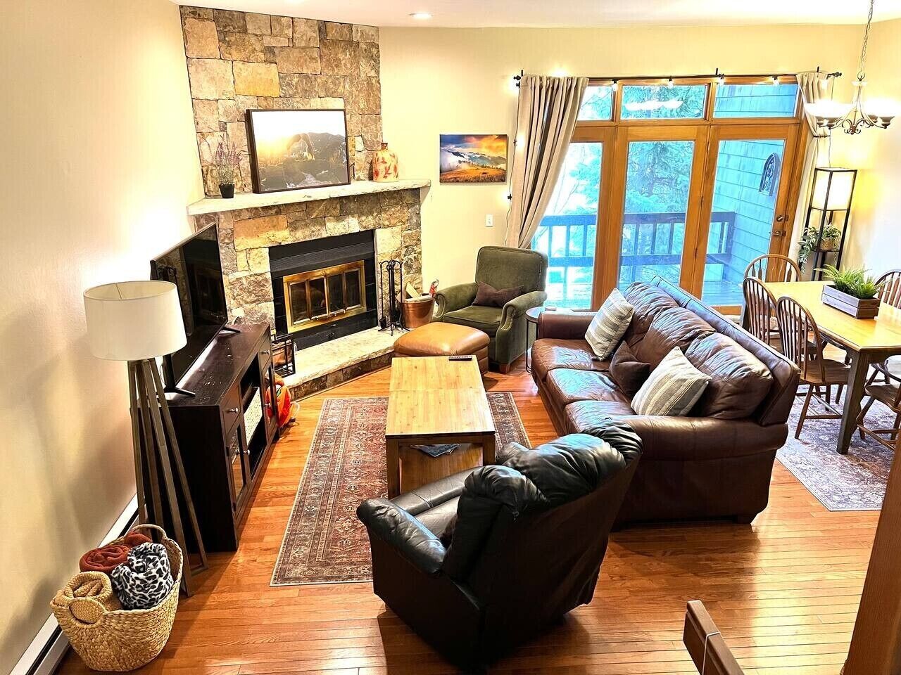 A cozy living room with a fireplace, leather sofa, and a dining area.