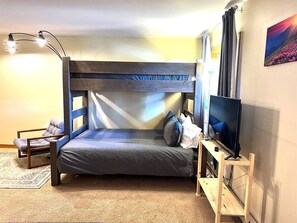 A bunk bed with a television on a stand, a chair, and a painting on the wall. - 3 Bedroom Townhome 1 Block from Main St Frisco (Frisco)