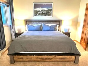 A bed with a wooden frame, two bedside lamps, and a framed picture on the wall. - 3 Bedroom Townhome 1 Block from Main St Frisco (Frisco)