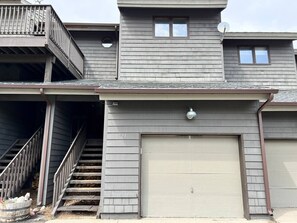 A two-story building with a garage door, a balcony, and a staircase leading to the upper floor. - 3 Bedroom Townhome 1 Block from Main St Frisco (Frisco)