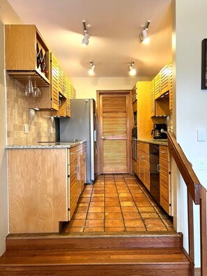 A kitchen with wooden cabinets, a tiled backsplash, and a central island. - 3 Bedroom Townhome 1 Block from Main St Frisco (Frisco)
