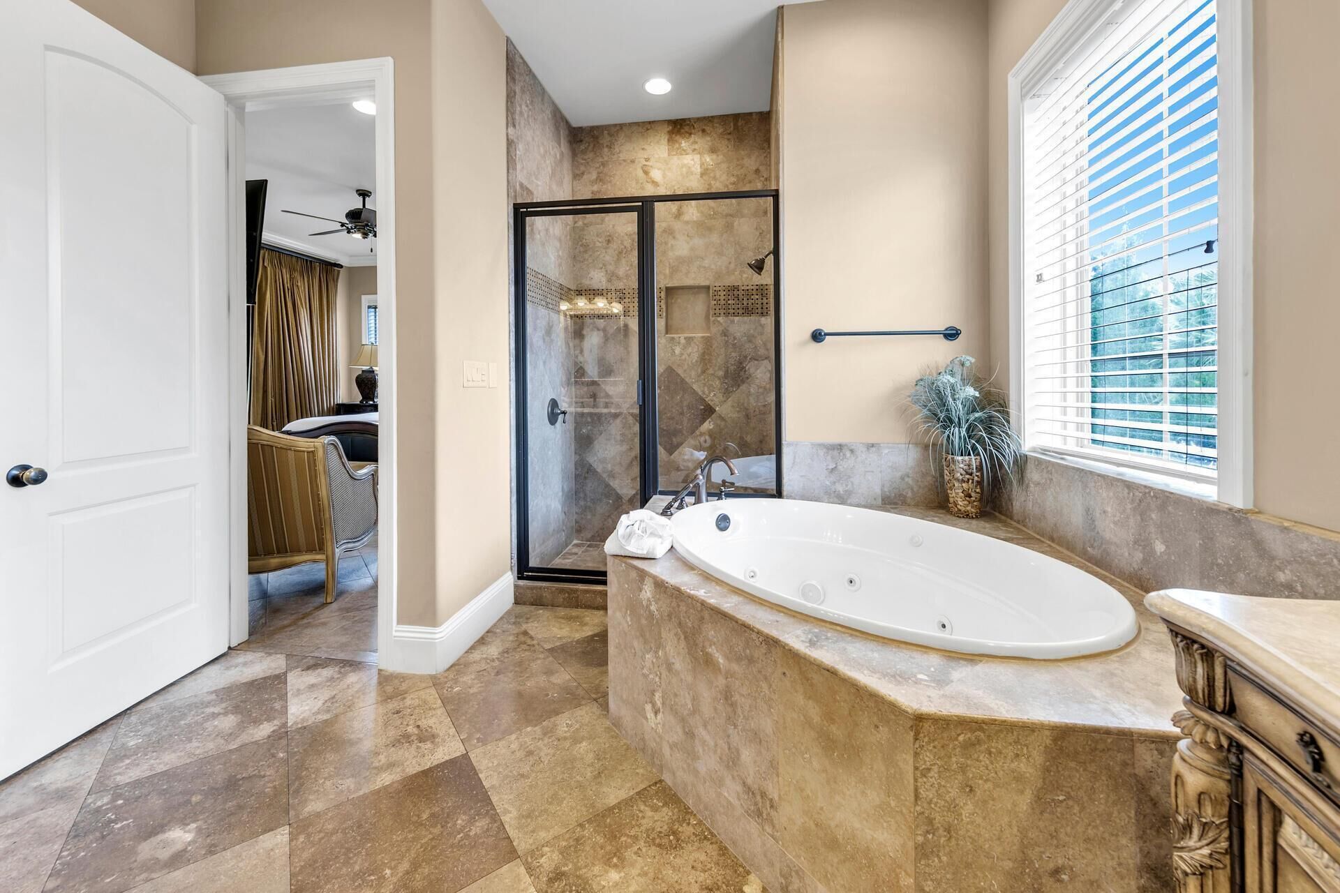 A bathroom with a large freestanding bathtub, a walk-in shower, and a vanity with a sink.