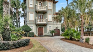 A two-story building with a balcony, surrounded by palm trees and a well-maintained garden. - Monaco (Miramar Beach)