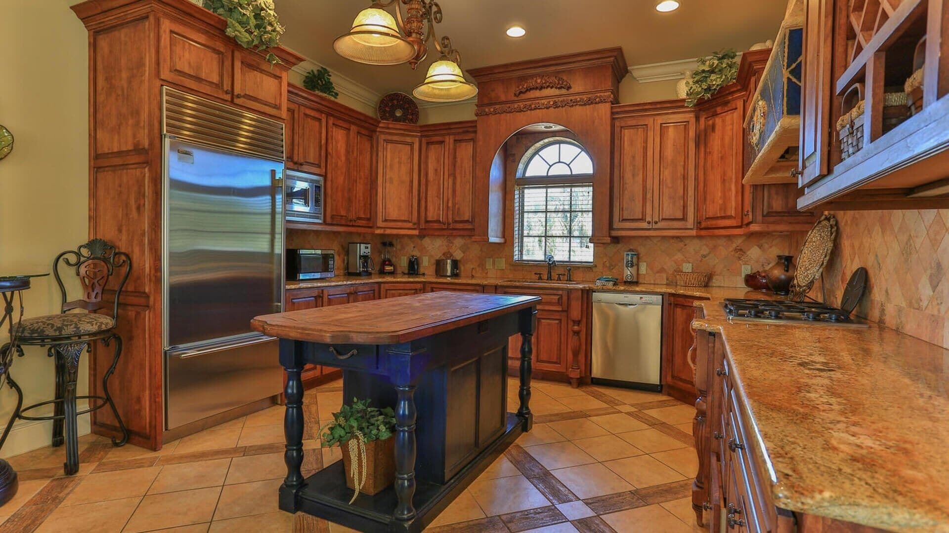 A spacious kitchen with wooden cabinets, stainless steel appliances, and a large island.