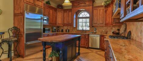 A spacious kitchen with wooden cabinets, stainless steel appliances, and a large island.