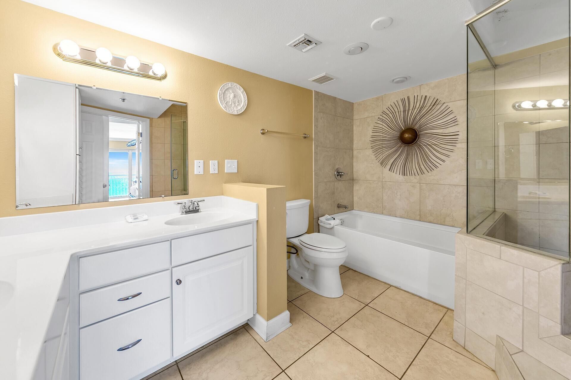 A modern bathroom with a large vanity, a toilet, a bathtub, and a shower.